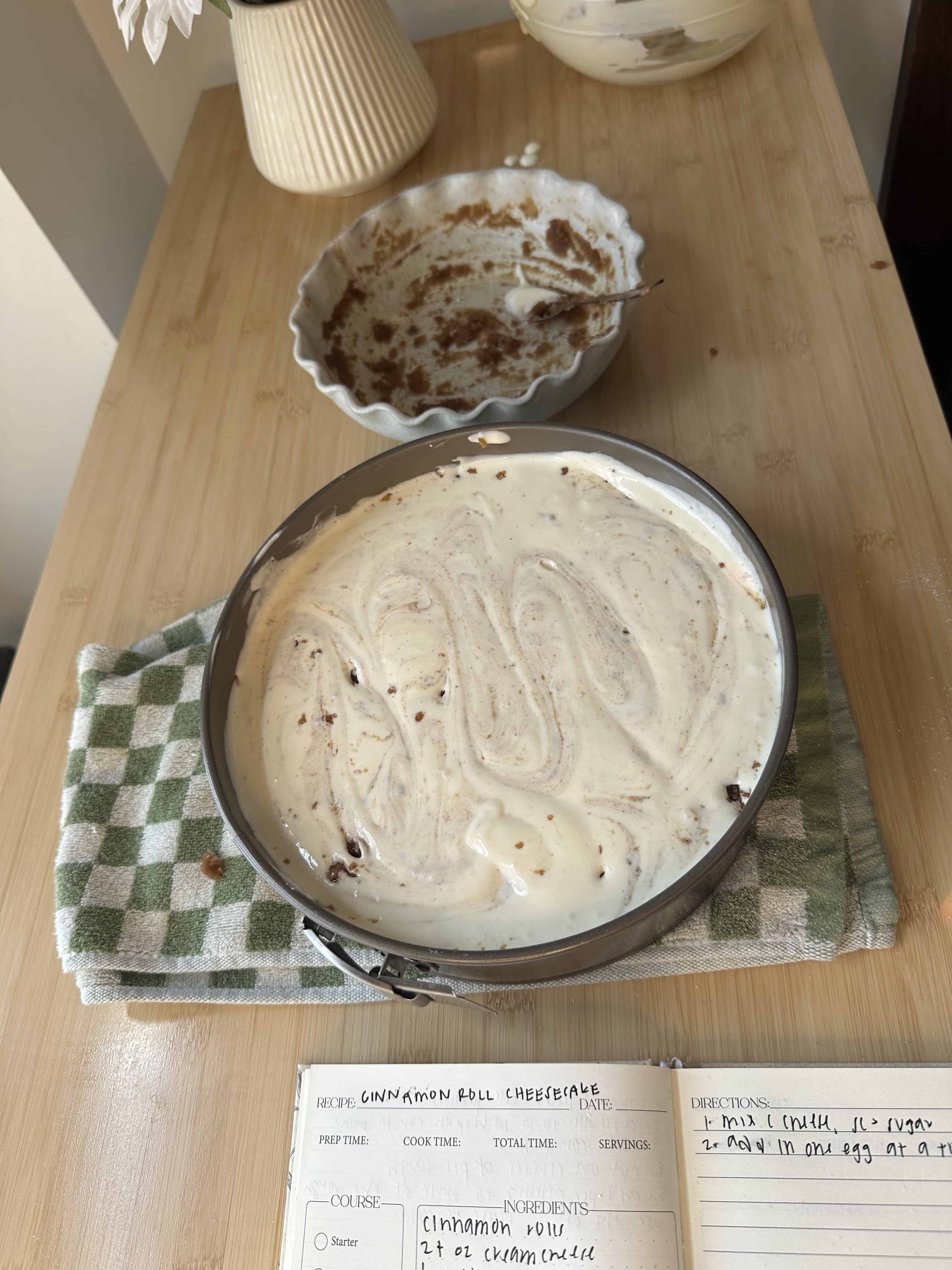 Cinnamon sugar mixture being swirled into the cheesecake batter.