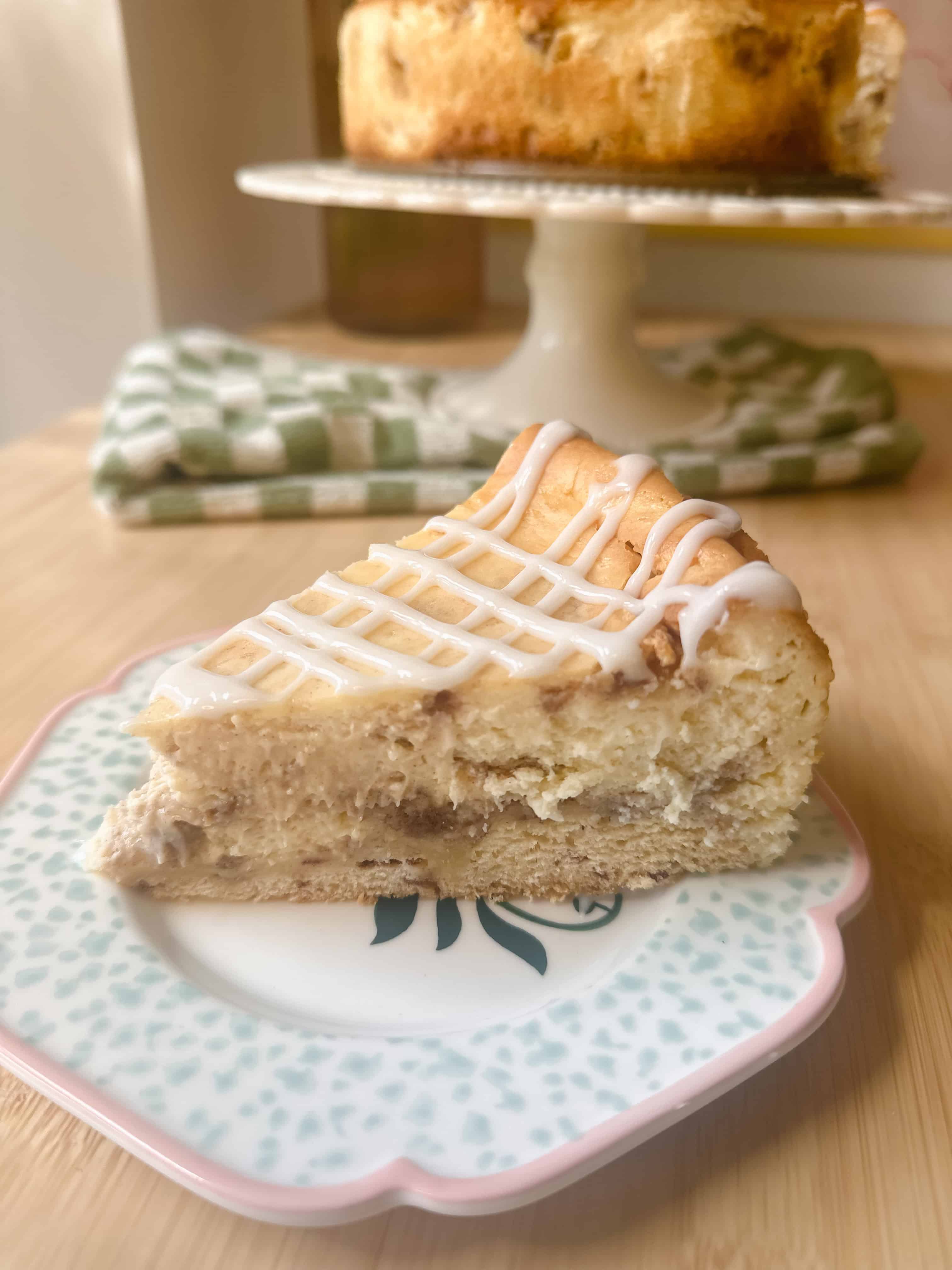 Cinnamon Roll Cheesecake slice showing layers of creamy cheesecake and cinnamon roll base.