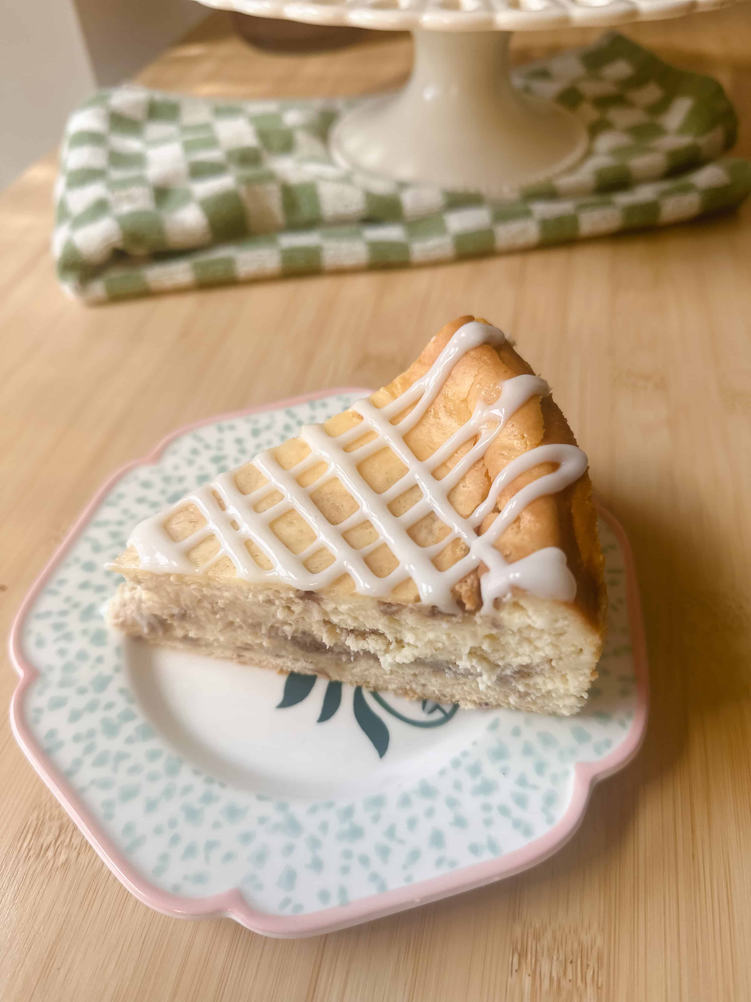 Cinnamon Roll Cheesecake slice showing layers of creamy cheesecake and cinnamon roll base.