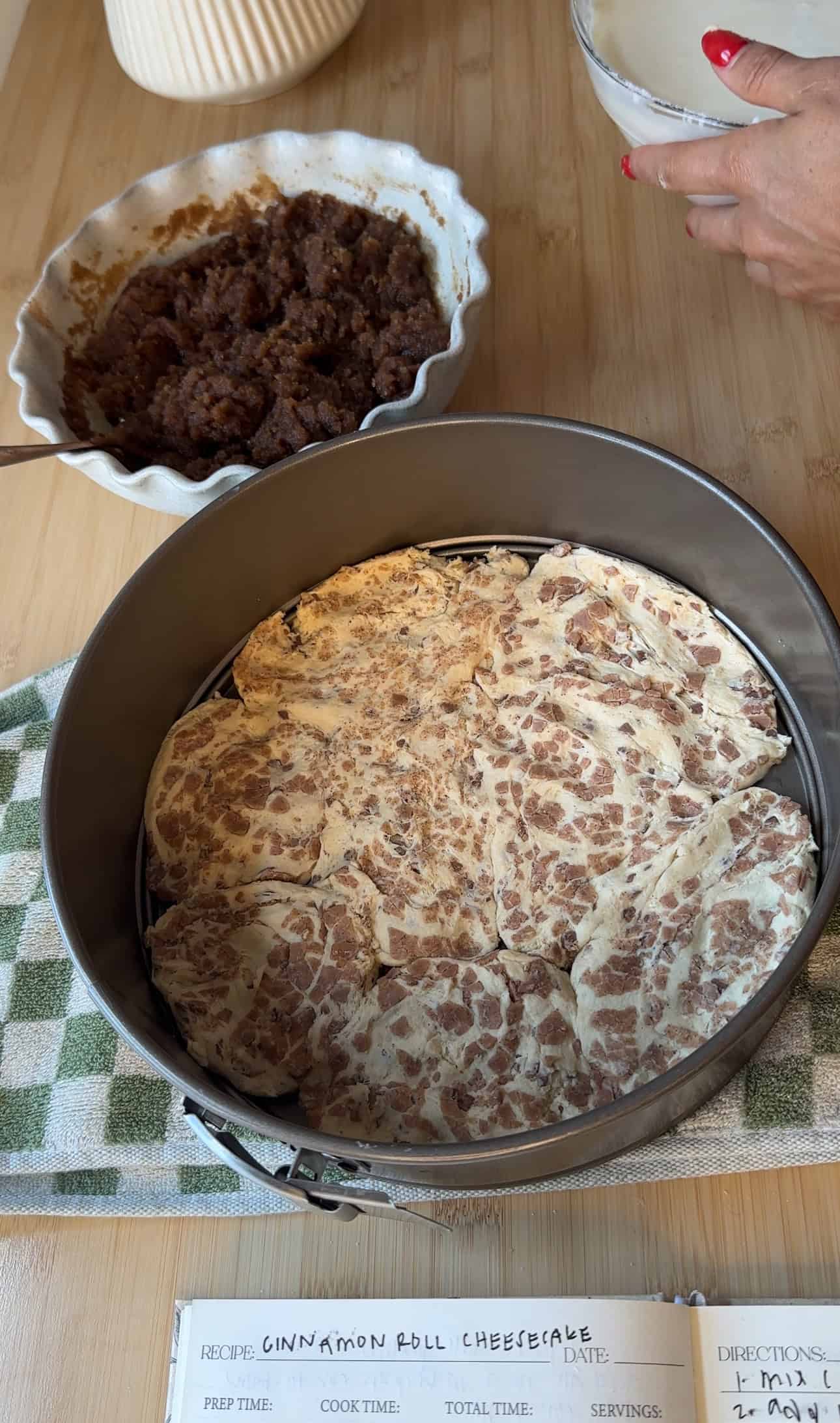 Springform pan with pressed Pillsbury cinnamon rolls as the crust for the cheesecake.