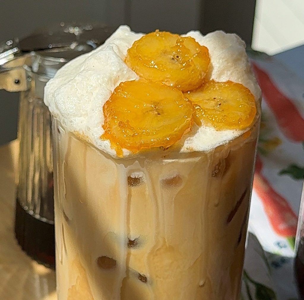 a very close up of my banana bread latte topped with caramelized bananas