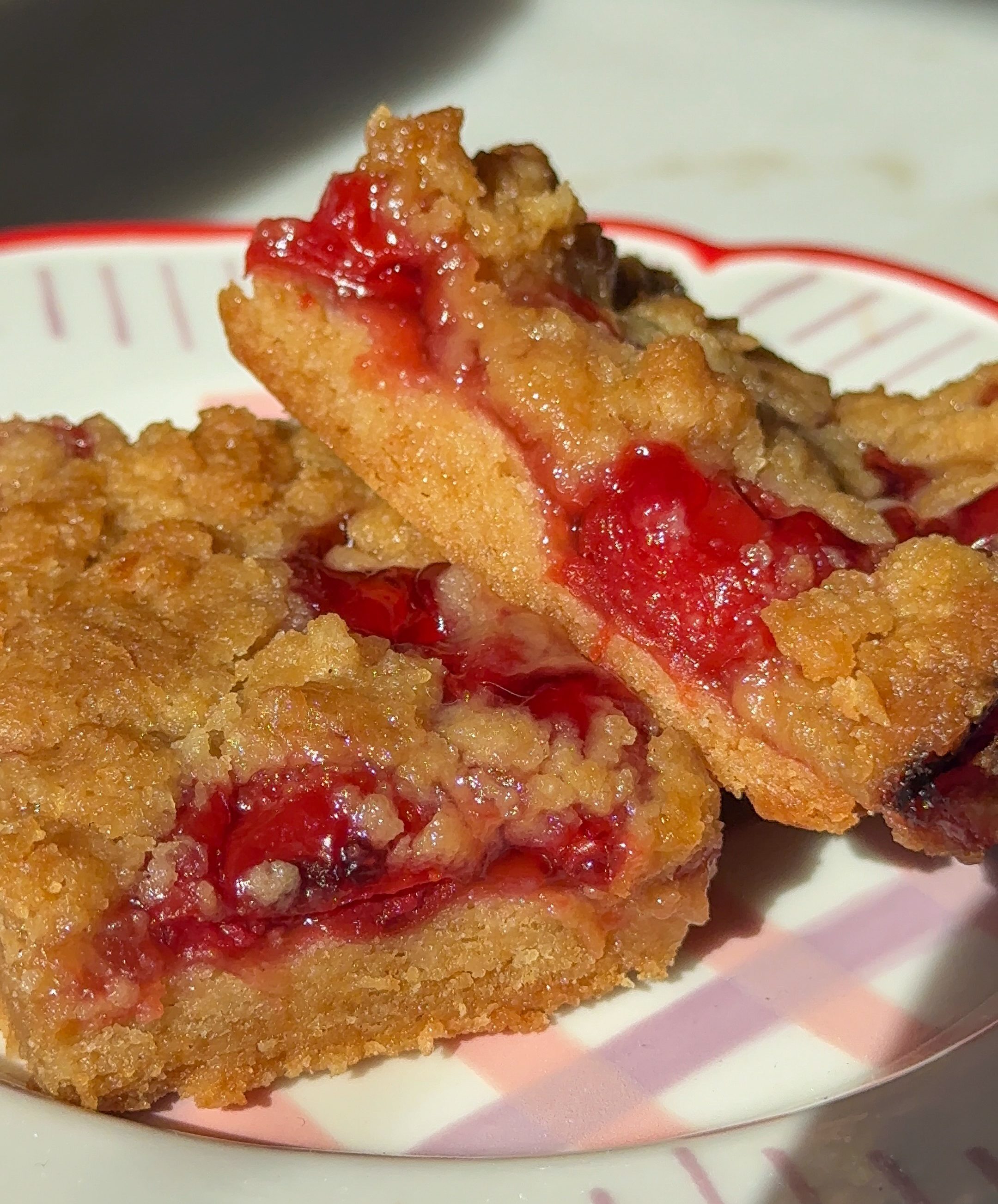 a close up of two cherry pie bars stacked on top of each other on a colorful plate