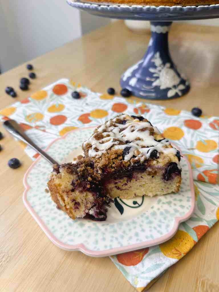 A close-up shot showing the moist, tender crumb of the cake, juicy blueberries, and crunchy crumble topping.