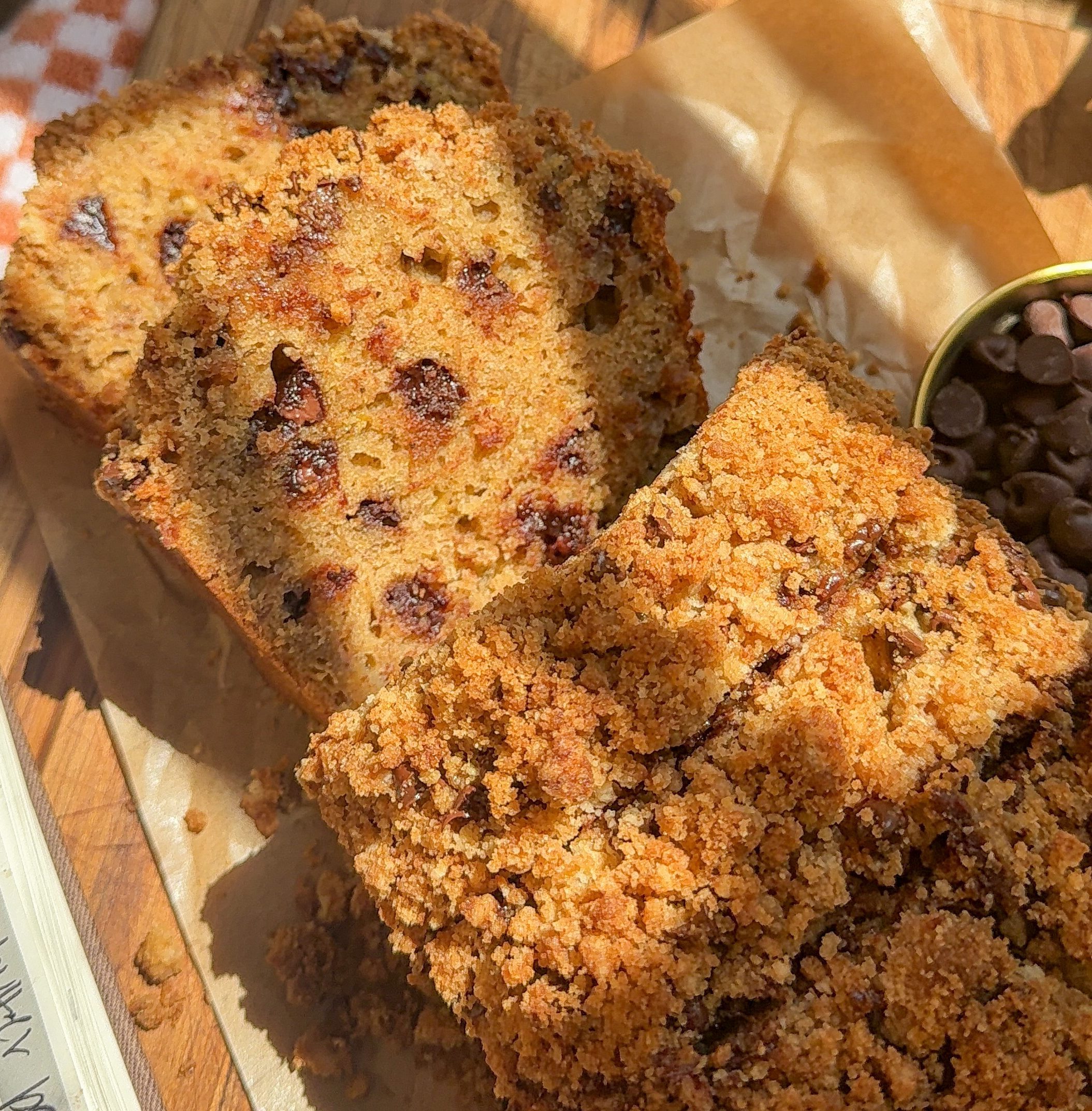 a close up of my Brown Butter Chocolate Chip Crumble Banana Bread sliced on a cutting board