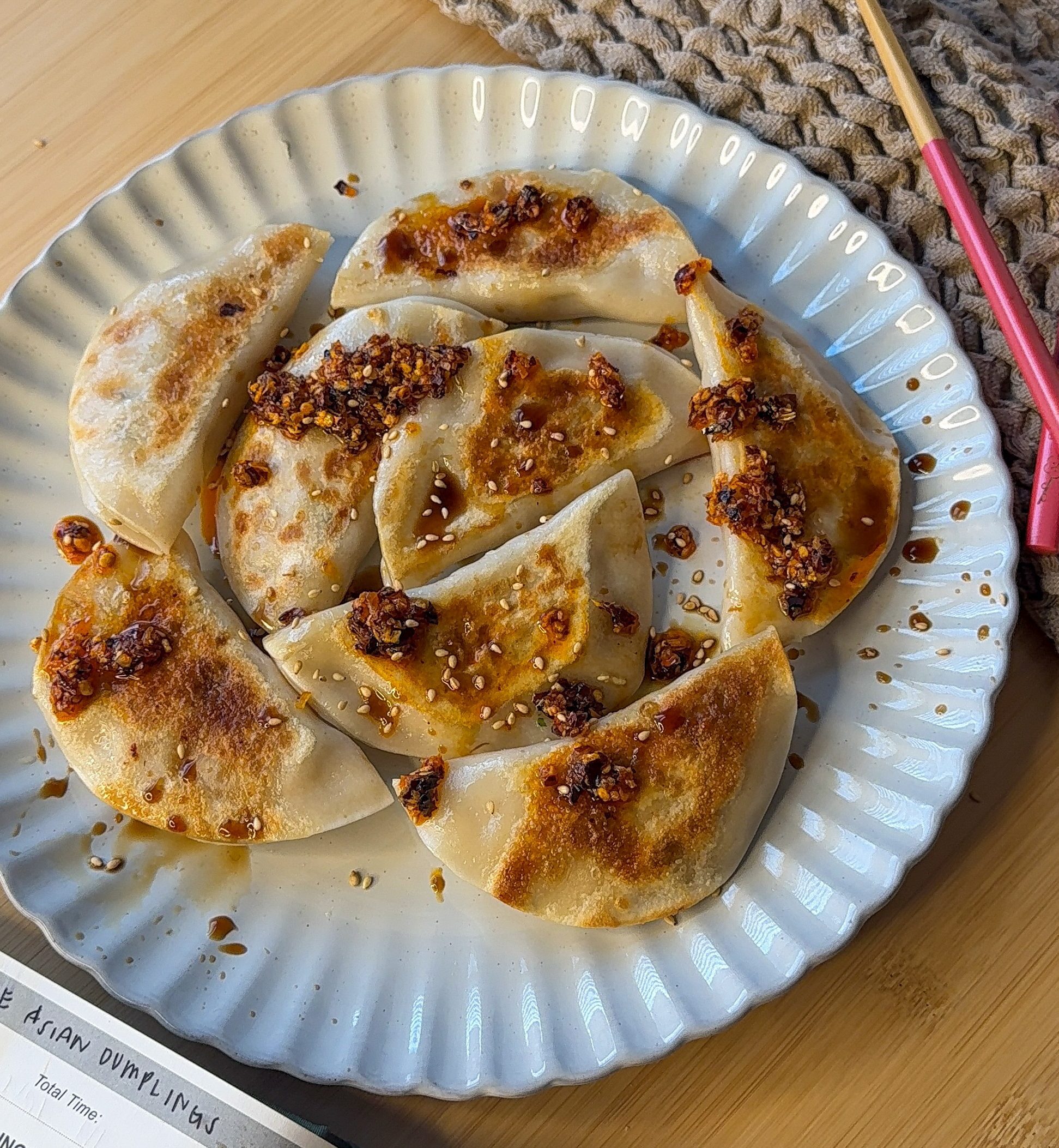 a plate of freshly panfried chicken and veggie dumplings with chili garlic and soy sauce