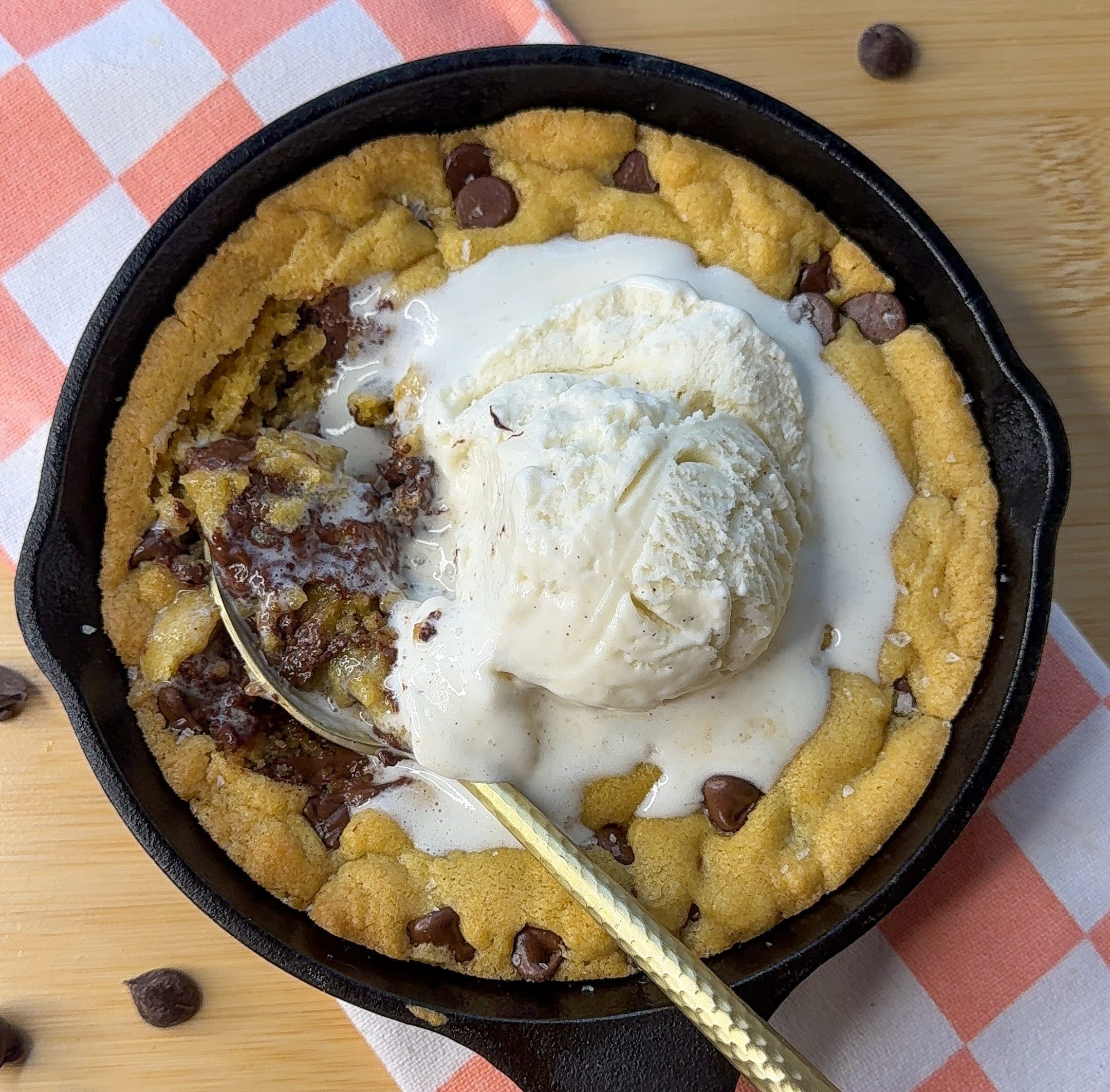 my skillet cookie for two topped with vanilla ice cream and eaten with a spoon